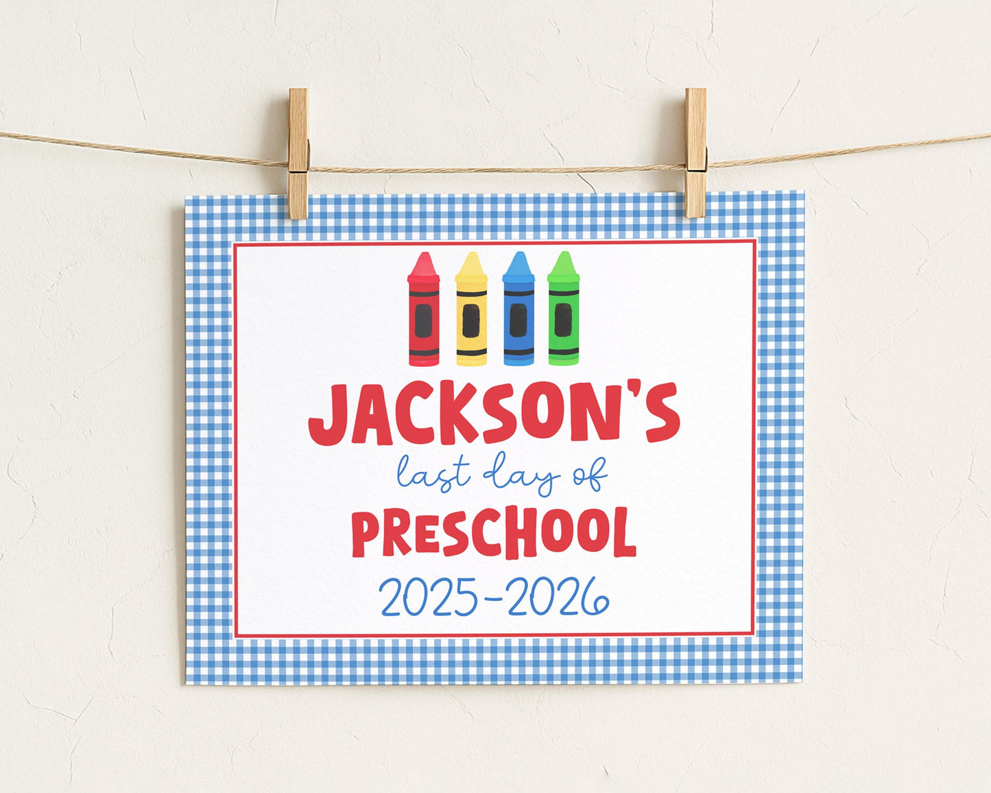 A sign with the text "JACKSON'S last day of PRESCHOOL" and colorful crayon illustrations, indicating the end of preschool.