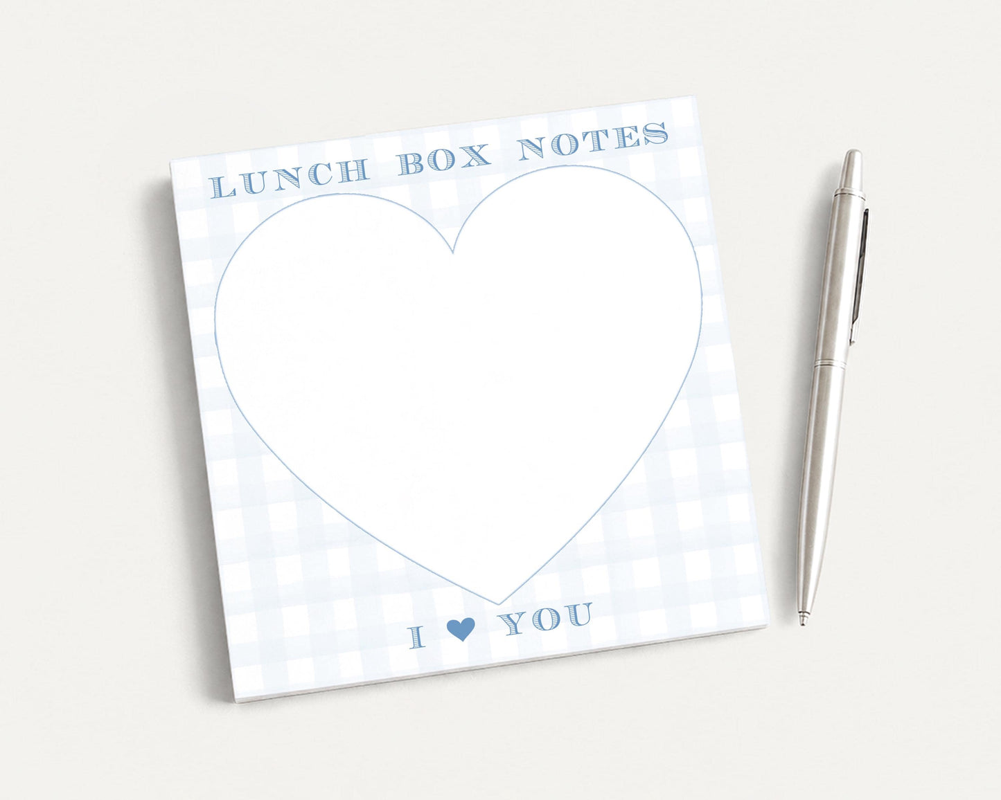 a heart-shaped blank pad with the text "I ❤ YOU" written on it, accompanied by a pen on a plain white background.