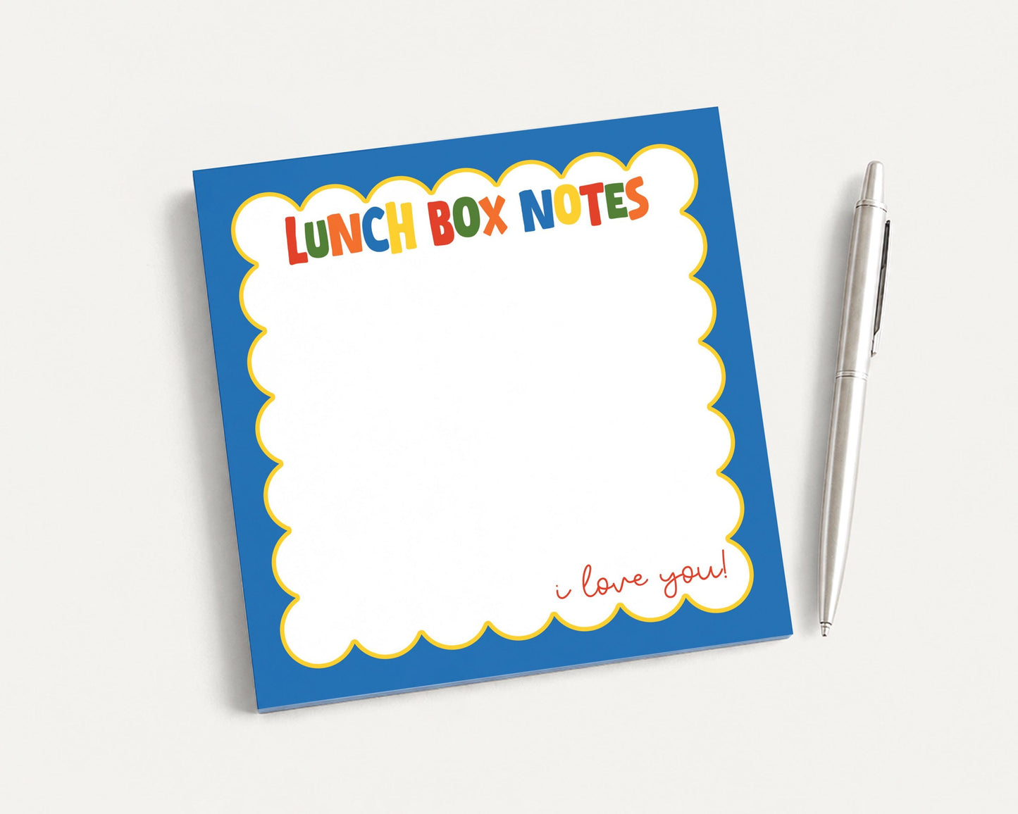 A blue and yellow lunch box with a blank space for writing and a pen next to it.