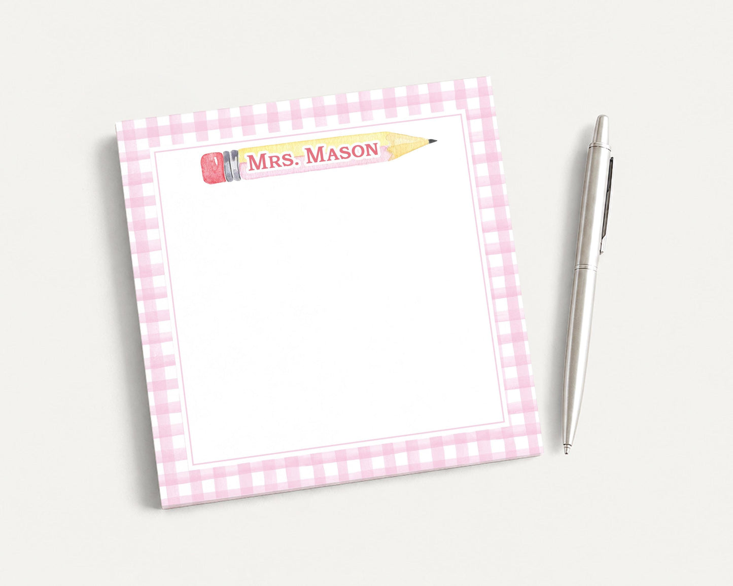 A pink and white checkered notepad with a pen on a white background.