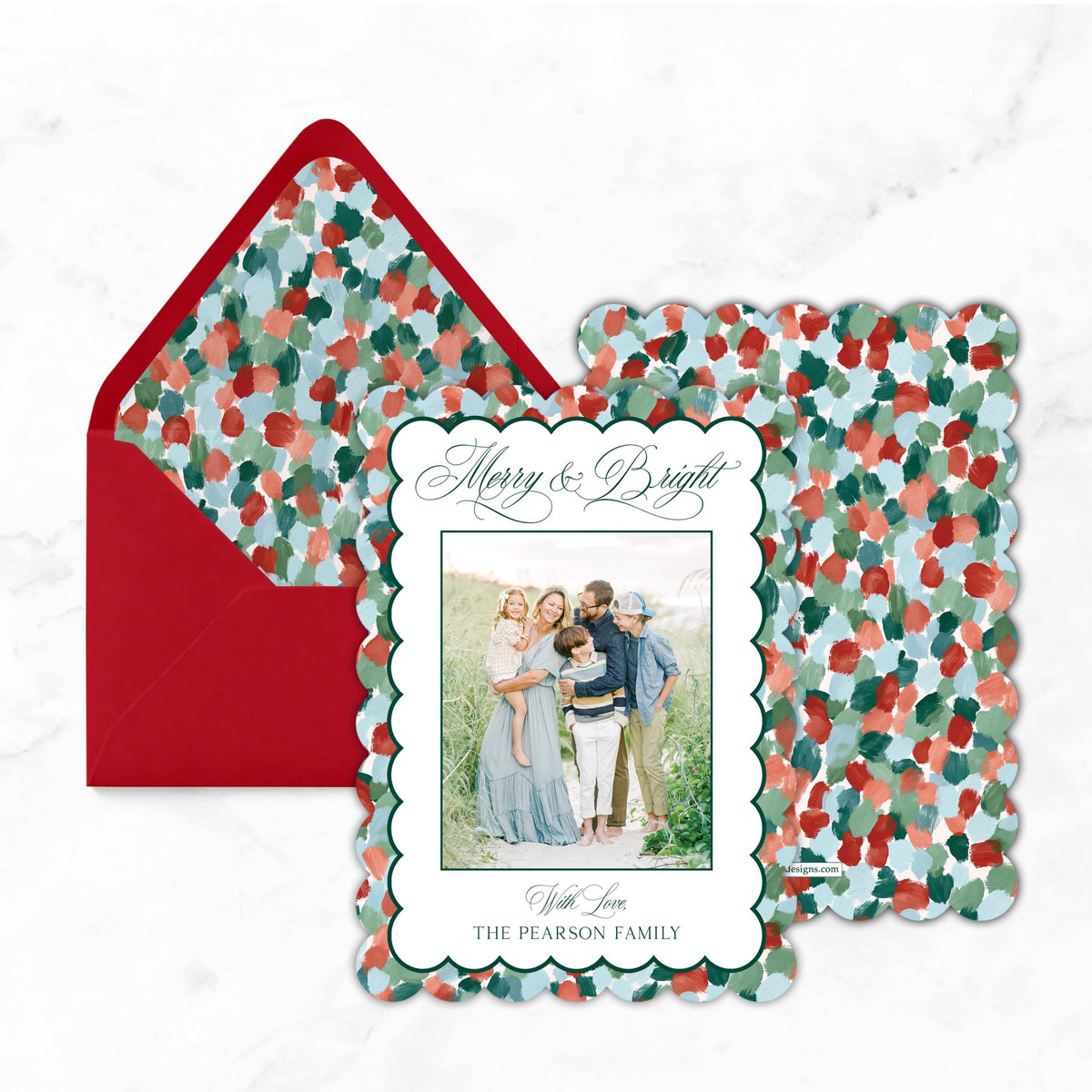 A holiday-themed card with a family photo and a red envelope with a floral pattern.