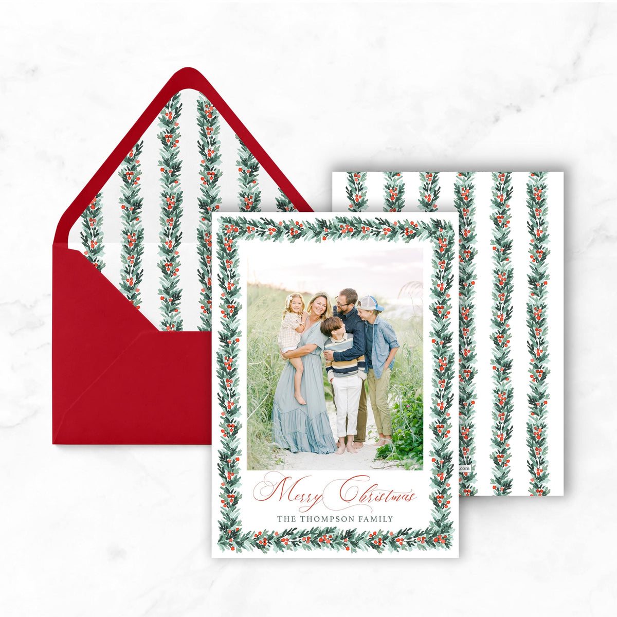 A Christmas card with a family photo and a red envelope with a matching red flap.