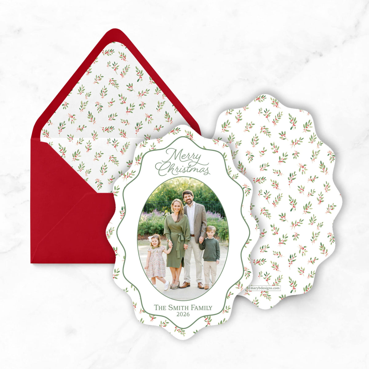 A Christmas card featuring a family photo of a man, woman, and two children, along with the text "Merry Christmas" and "The Smith Family 2020". The card is placed on top of a red envelope with a white floral pattern.