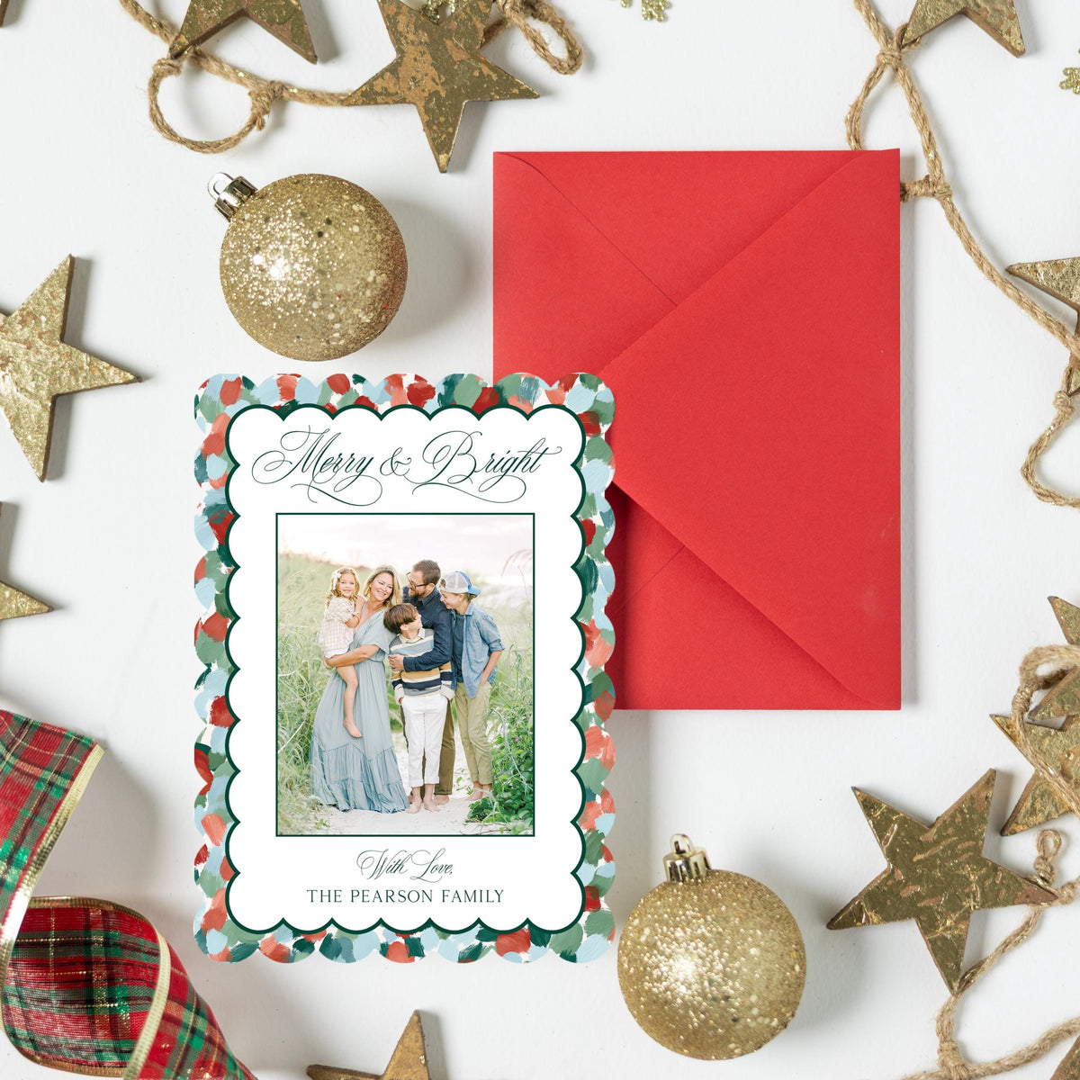 a festive arrangement of Christmas decorations, including a red envelope, gold ornaments, and star-shaped decorations.