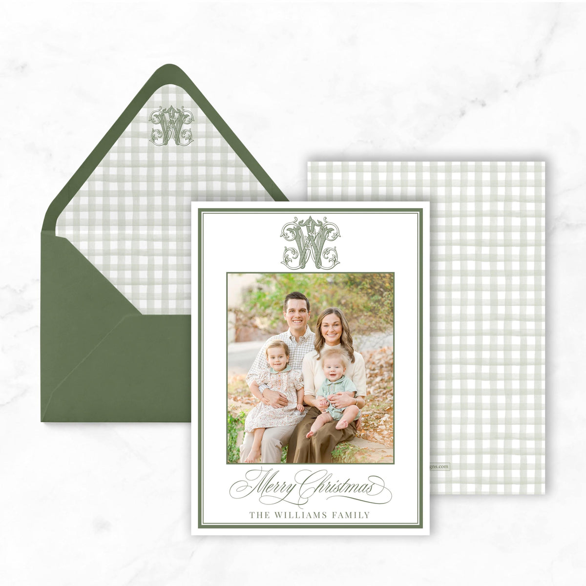 A family portrait of a man, woman, and two children is displayed on a card, along with an envelope and a checkerboard background.