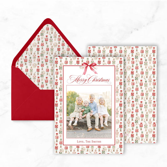 A Christmas card with a red envelope and a photo of three children sitting on a bench.