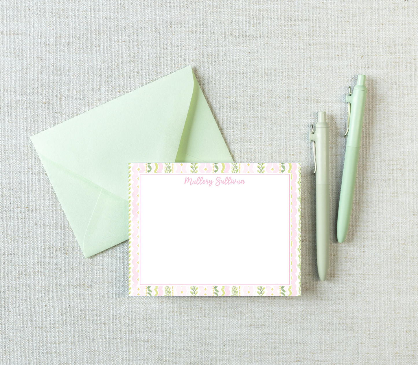 a green envelope, a blank card with a floral border, and two pens on a light-colored surface. __etsy:8185217660