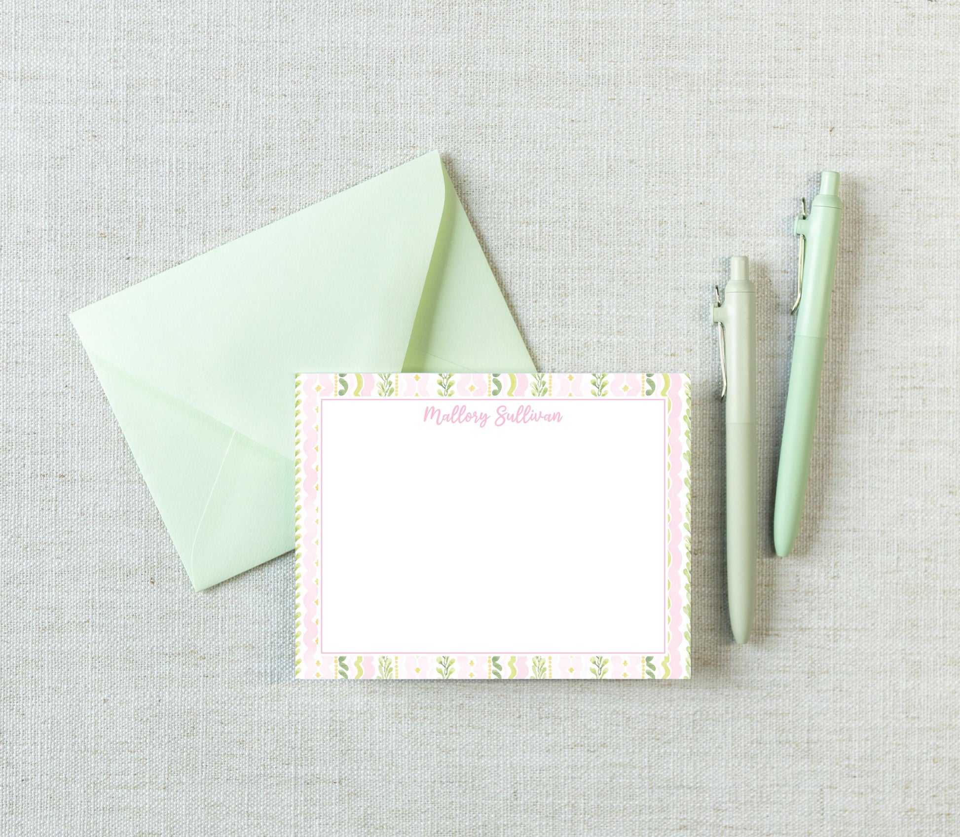 a green envelope, a blank card with a floral border, and two pens on a light-colored surface. __etsy:8185217660