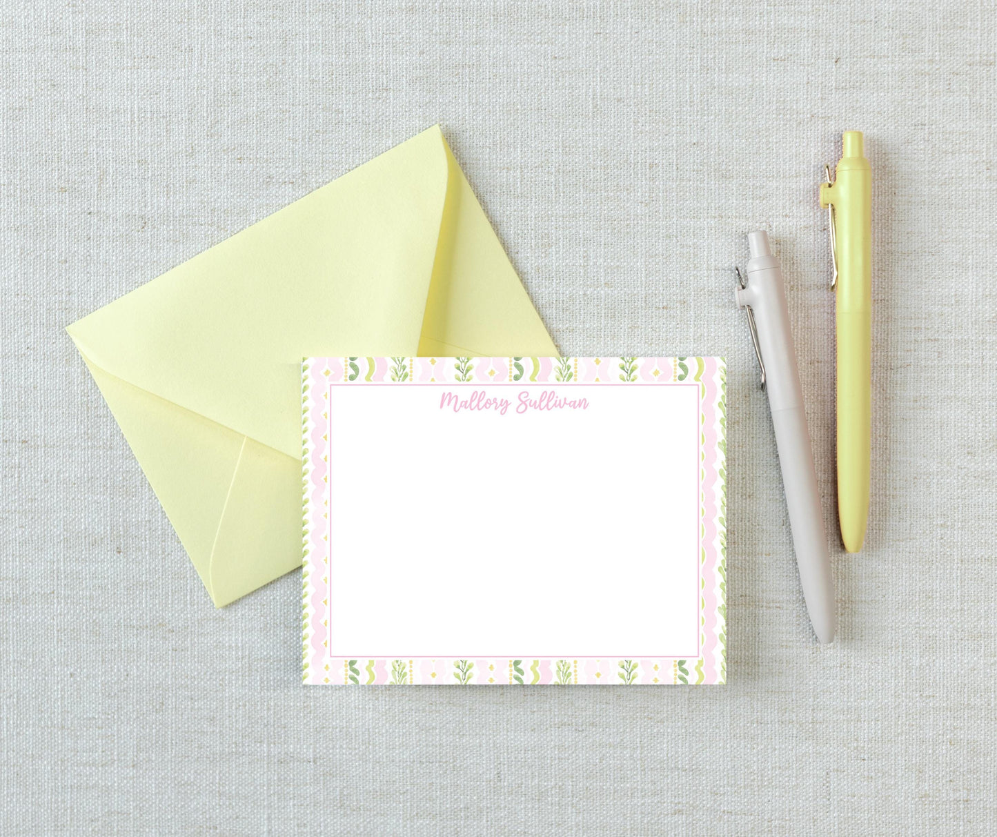 a yellow envelope, a blank card with a pink border, and two pens on a light-colored surface. __etsy:8233148437