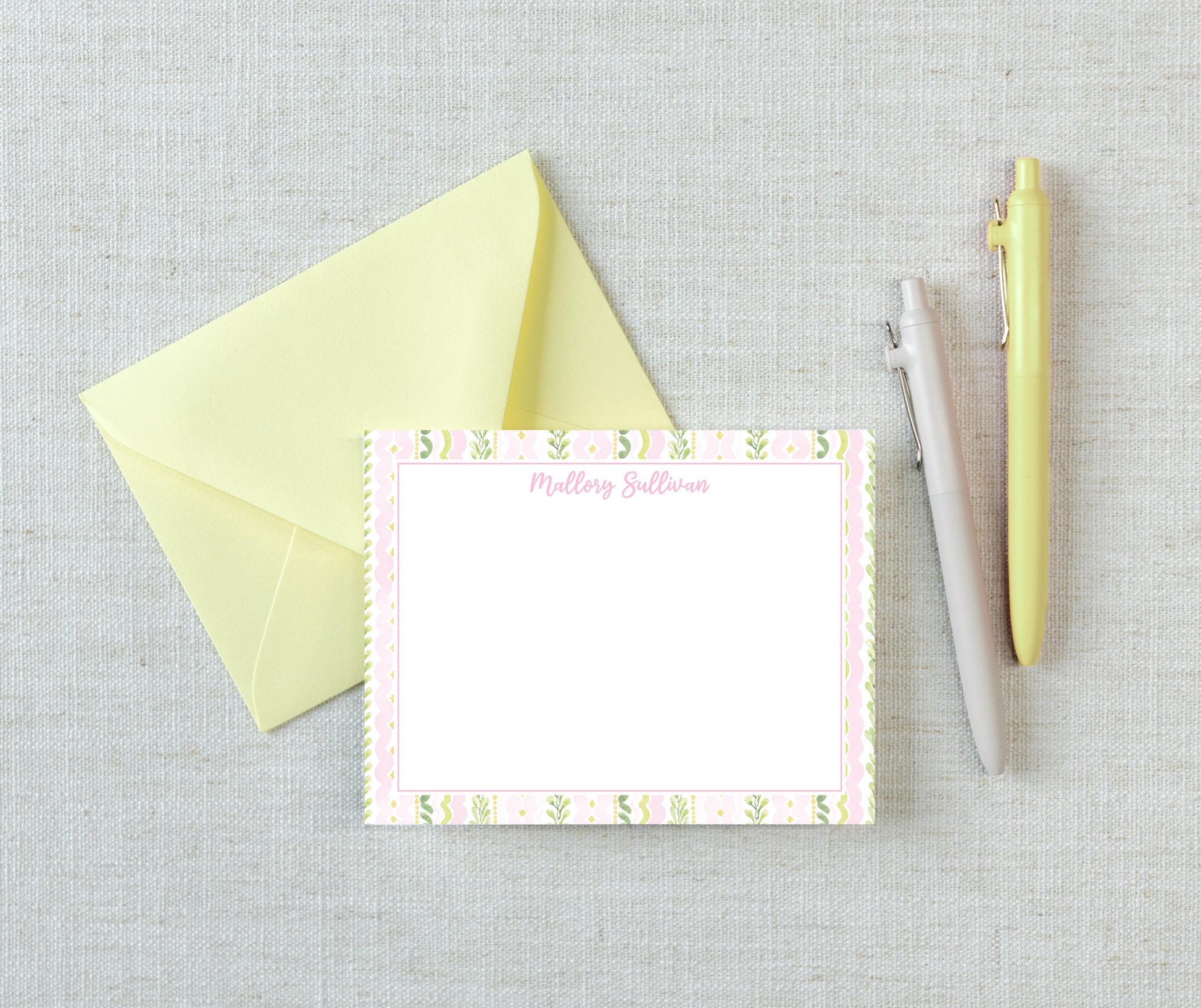 a yellow envelope, a blank card with a pink border, and two pens on a light-colored surface. __etsy:8233148437
