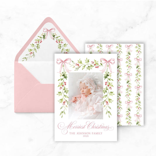 A pink envelope with a photo of a baby inside, and a matching card with a floral design and text.