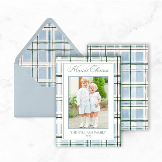 A greeting card with a photo of two young children, likely siblings, and the text "Merry Christmas" and "THE WILLIAMS FAMILY 2026" printed on it.