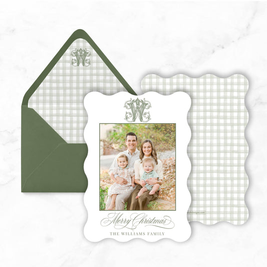 A family portrait of a man, woman, and two children is displayed in a scalloped frame, placed on top of an envelope and a white background.
