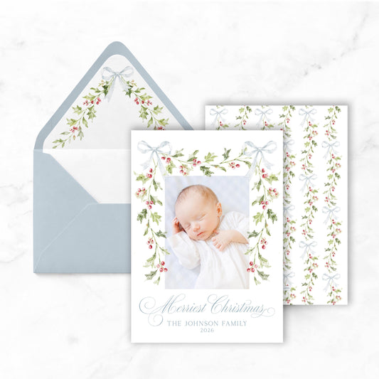 A greeting card with a photo of a baby and a bow, placed on a marble surface.