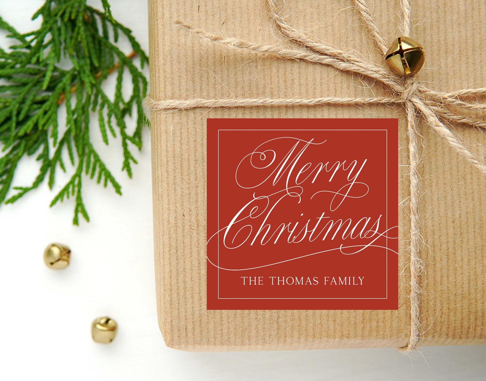 May include: A red square gift tag with white cursive text that reads 'Merry Christmas' and 'THE THOMAS FAMILY'.