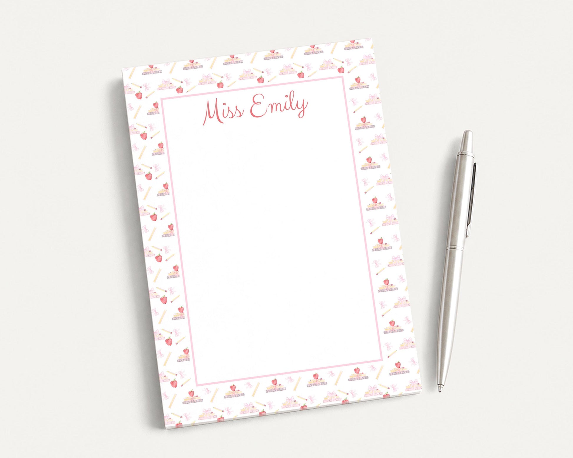 a blank nameplate with a pink and white patterned border, placed next to a pen on a white surface.