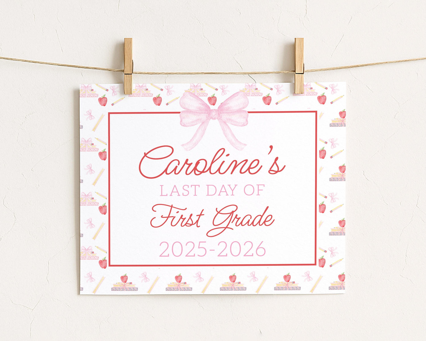 A white sign with a pink bow and a ribbon, displaying the text "Caroline's LAST DAY OF FIRST GRADE 2015-2026"