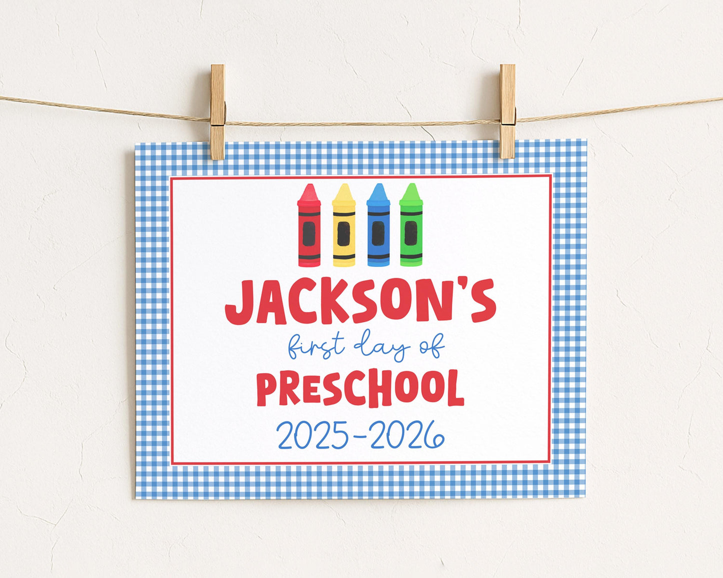 A sign with the text "JACKSON'S first day of preschool" and colorful crayon illustrations, indicating the start of a new school year.