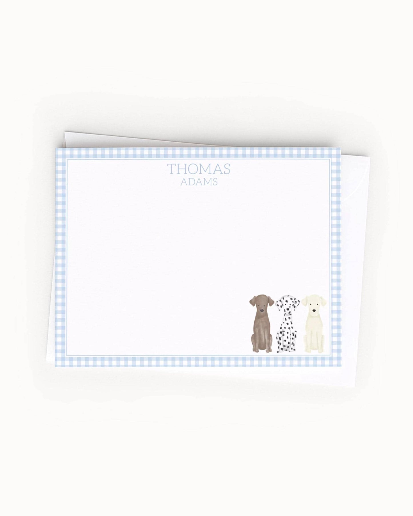A blank card with a blue and white checkered border, featuring illustrations of three dogs of different breeds.