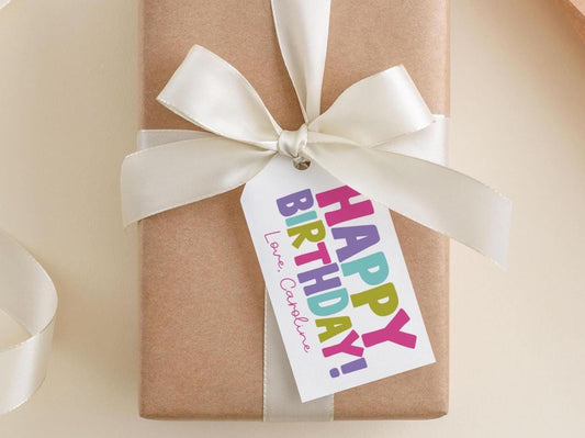 A brown gift box with a white ribbon and a tag that says "Happy Birthday!"