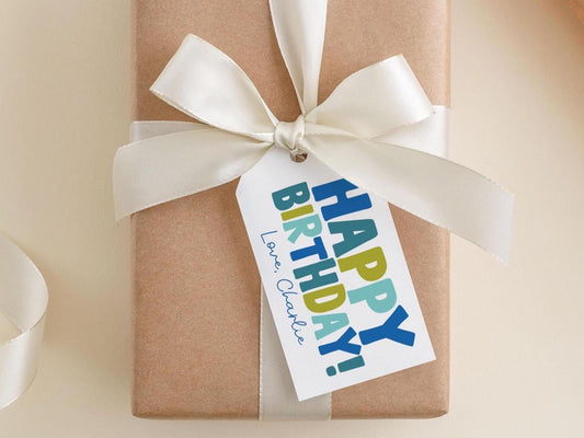 A brown gift box with a white ribbon and a tag that says "Happy Birthday Charlie".