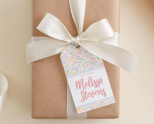 A gift wrapped in brown paper with a white ribbon and a tag that reads "A Gift From Melissa Stevens".