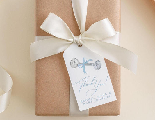A brown gift box with a white ribbon and a tag attached to it.