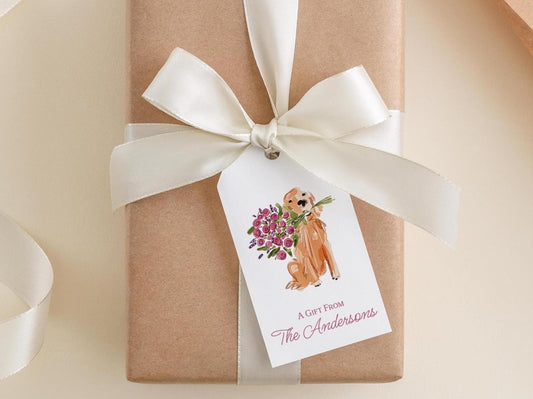 A gift wrapped in brown paper with a white ribbon and a tag featuring an illustration of a dog holding flowers.