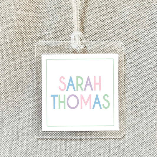 A clear name tag with the name "SARAH THOMAS" printed on it.