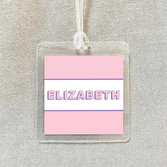 A clear plastic name tag with the name "ELIZABETH" printed on it in pink and white text.