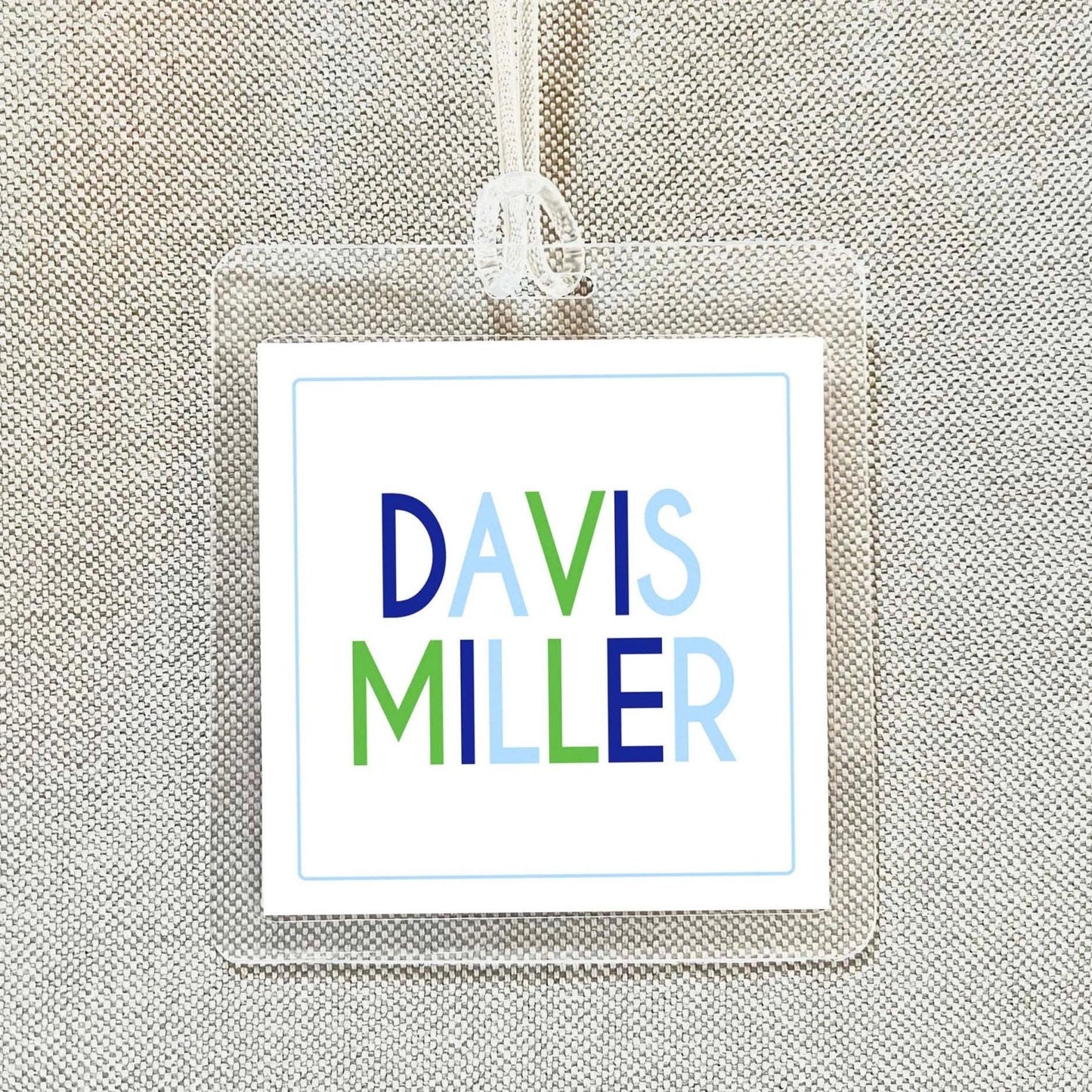 A clear plastic name tag with the name 'DAVIS MILLER' printed on it.