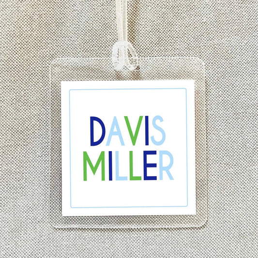 A clear plastic name tag with the name 'DAVIS MILLER' printed on it.