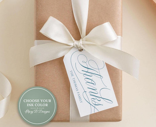 A brown gift box with a white ribbon and a white tag attached to it, which says "Thanks Thomas Family".