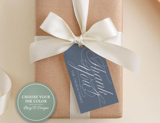 A brown gift box with a white ribbon and a blue tag that says "Thank you" in elegant cursive font.