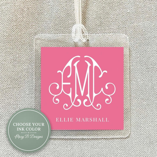 A pink square tag with a monogram design and the text "ELIE MARSHALL" printed on it.