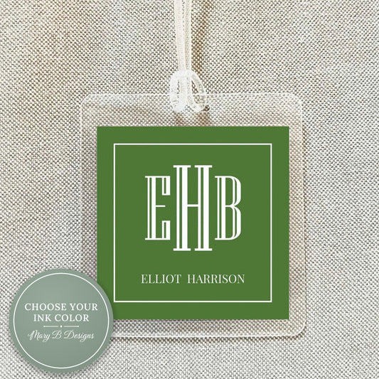 A clear luggage tag with a green square background and white text.