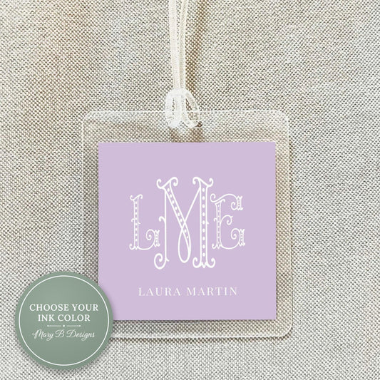 A clear plastic name tag with a purple background and the initials "LME" printed on it.