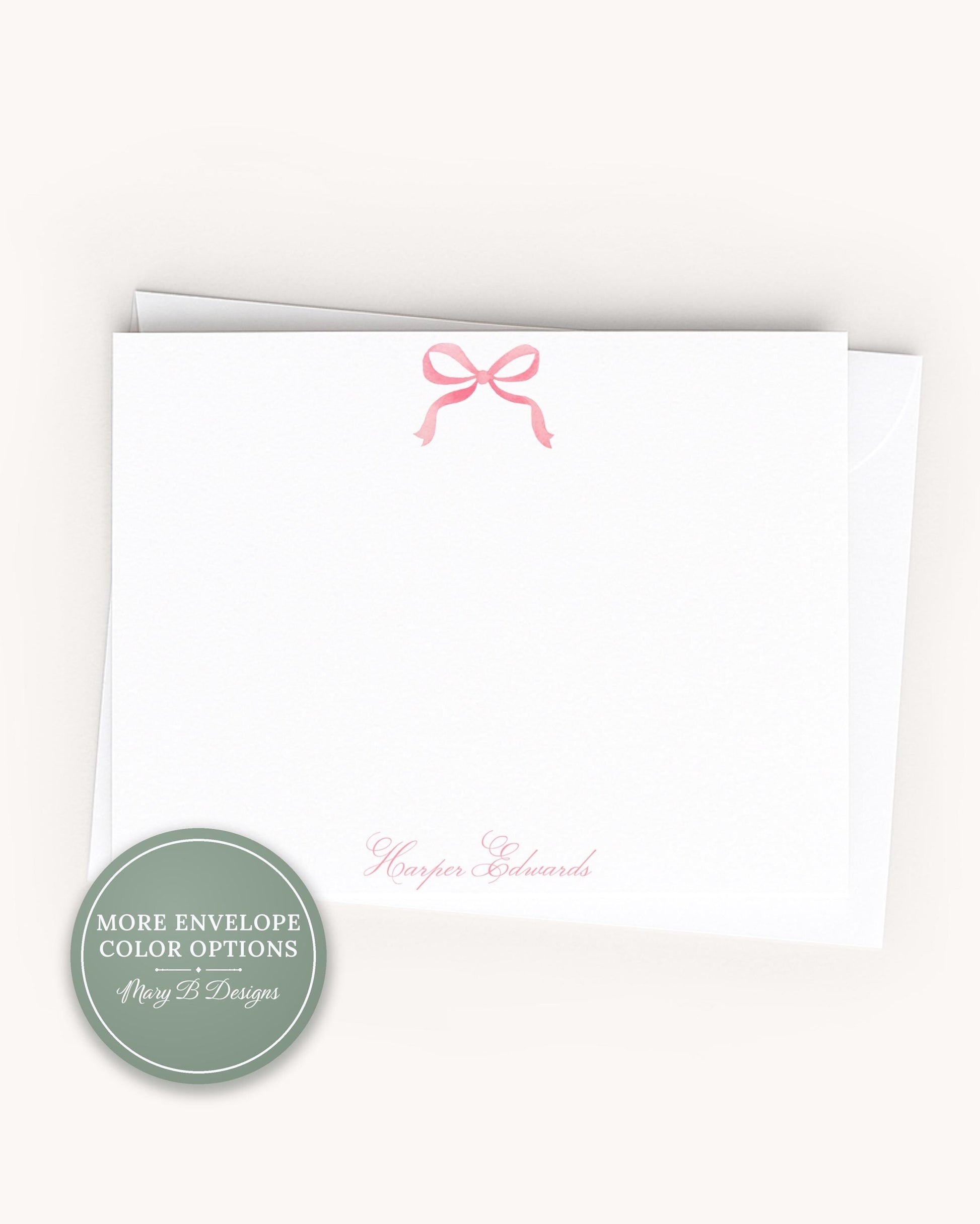 A white card with a pink bow on top, and the name "Harper Edwards" written on it.