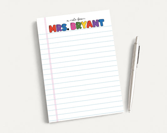 A lined notepad with the name "Mrs. Bryant" written on it, along with a pen, is placed on a white surface.