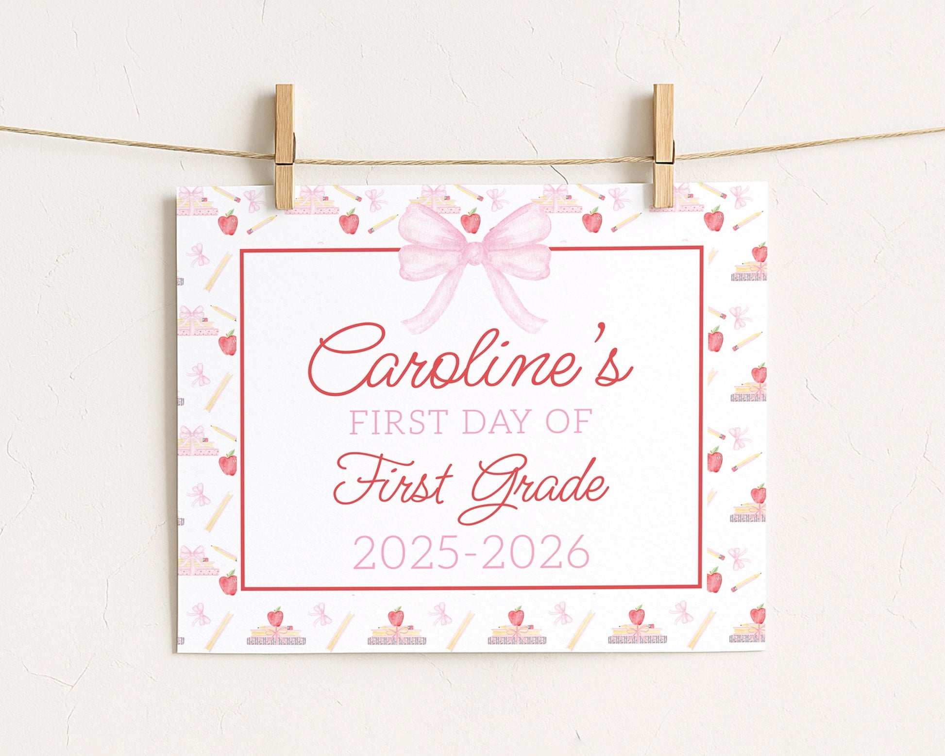 A white sign with a pink bow and the text "Caroline's FIRST DAY OF FIRST GRADE" is hanging on a string.