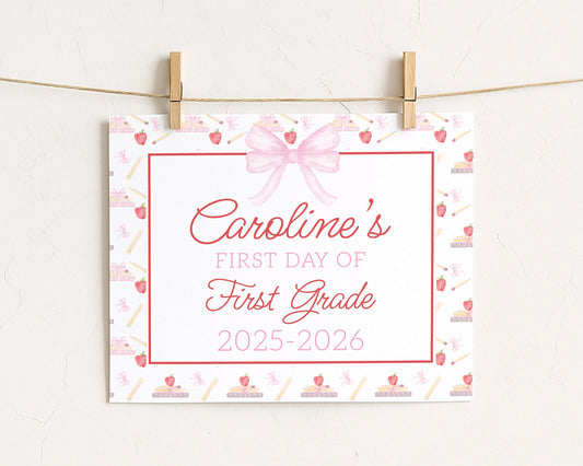 A white sign with a pink bow and the text "Caroline's FIRST DAY OF FIRST GRADE" is hanging on a string.