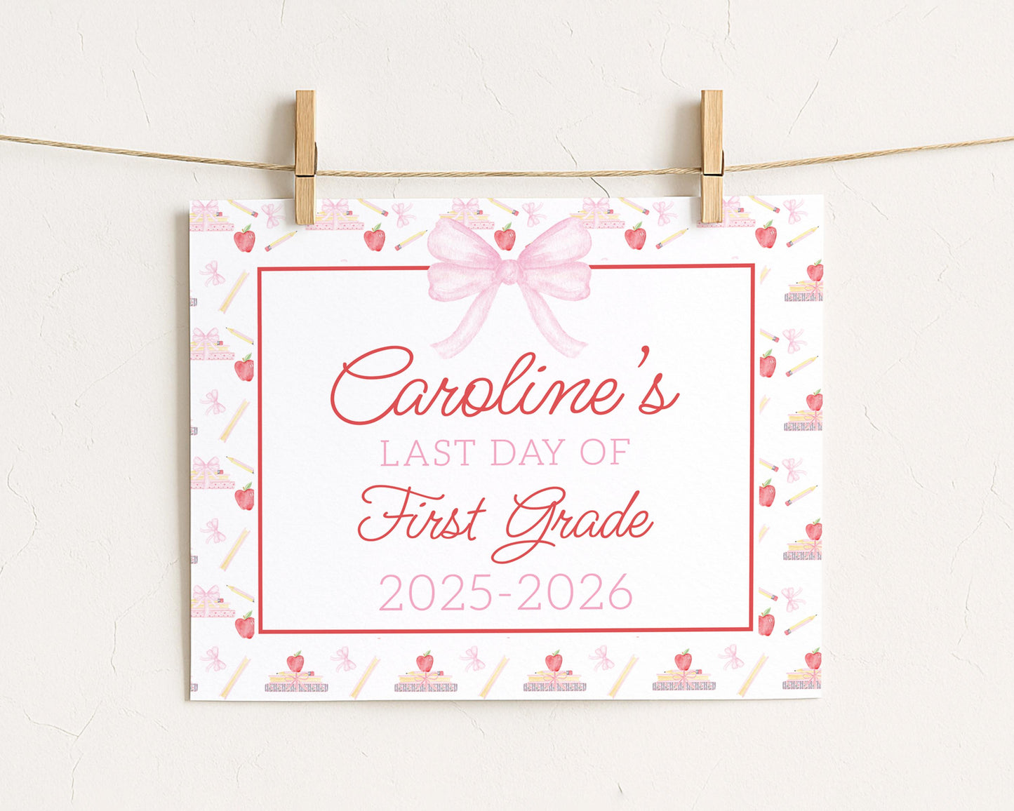 A white sign with a pink bow and a ribbon, displaying the text "Caroline's LAST DAY OF FIRST GRADE 2015-2026"
