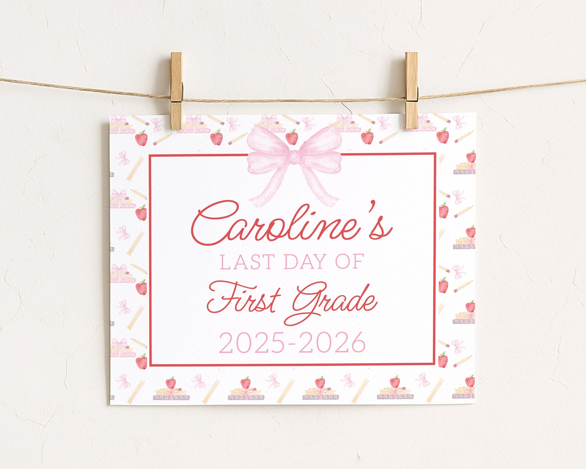 A white sign with a pink bow and a ribbon, displaying the text "Caroline's LAST DAY OF FIRST GRADE 2015-2026"
