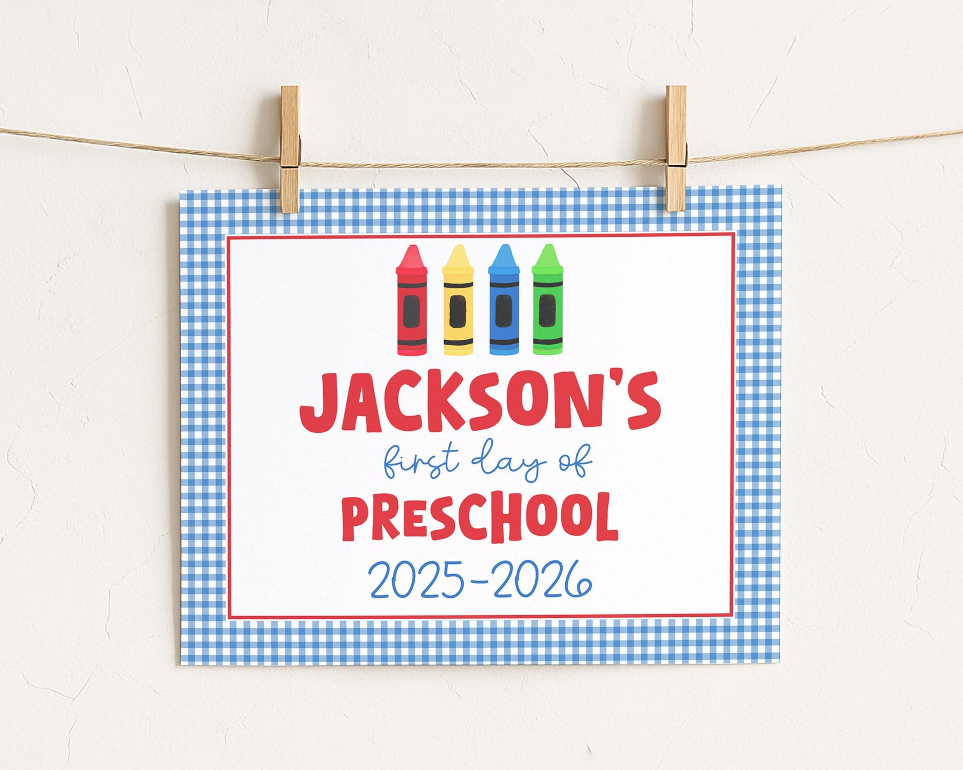 A sign with the text "JACKSON'S first day of preschool" and colorful crayon illustrations, indicating the start of a new school year.
