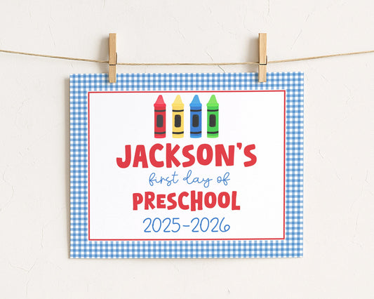 A sign with the text "JACKSON'S first day of preschool" and colorful crayon illustrations, indicating the start of a new school year.