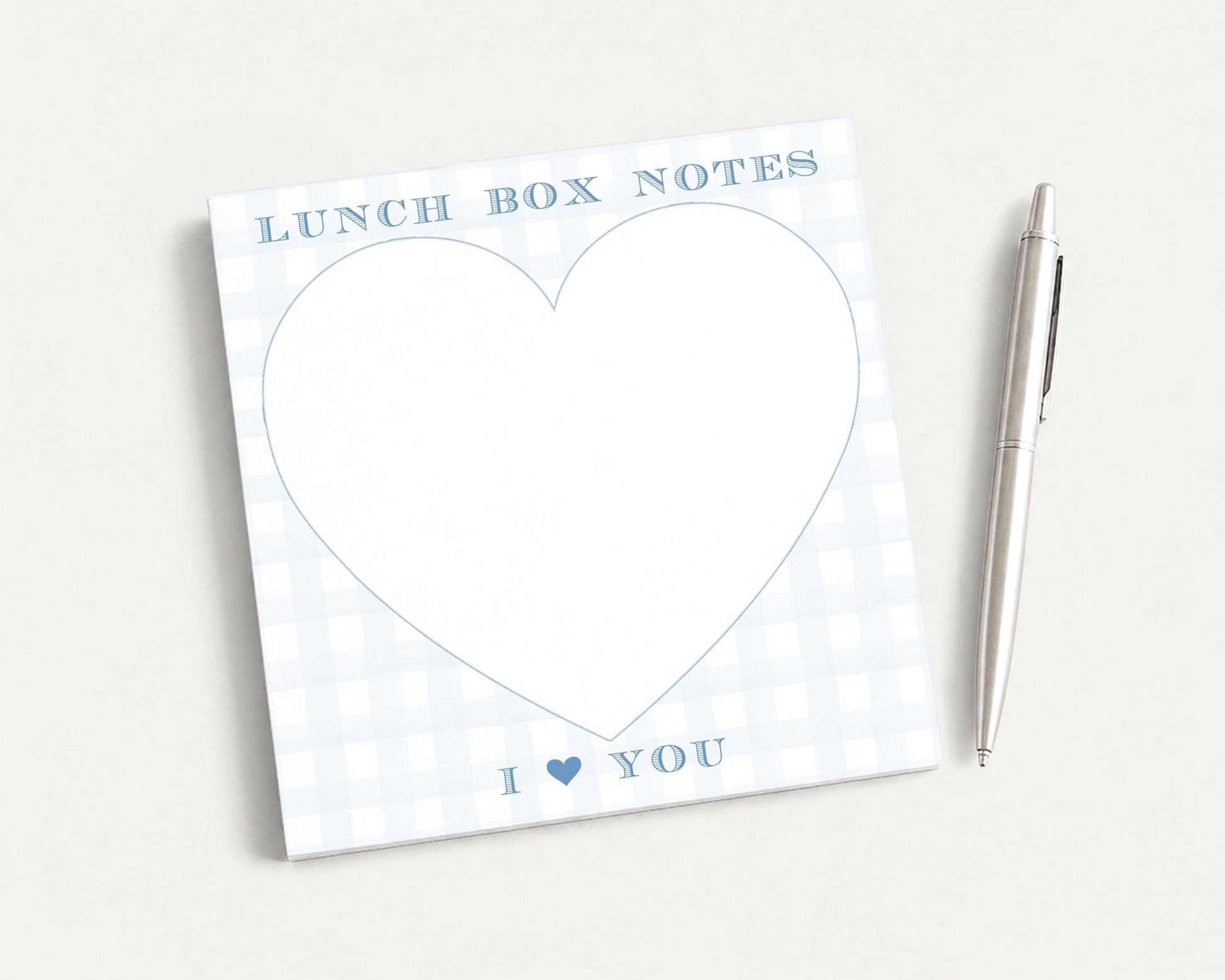 a heart-shaped blank pad with the text "I ❤ YOU" written on it, accompanied by a pen on a plain white background.