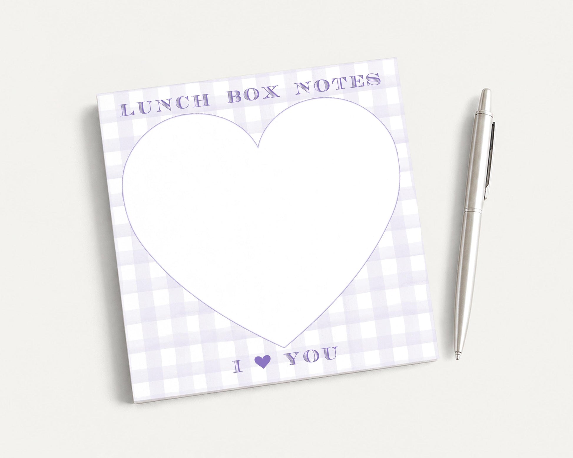 a heart-shaped blank pad with the text "I ❤ YOU" written on it, accompanied by a pen on a plain white background.