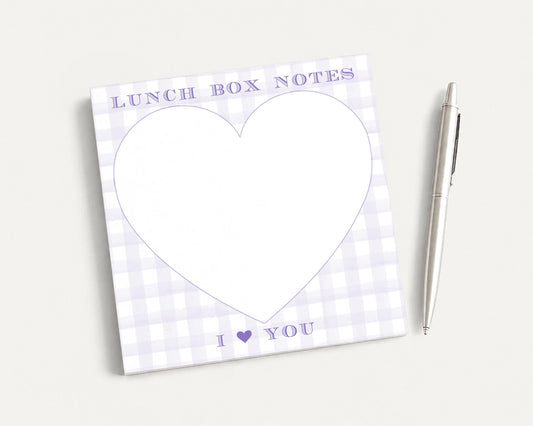 a heart-shaped blank pad with the text "I ❤ YOU" written on it, accompanied by a pen on a plain white background.