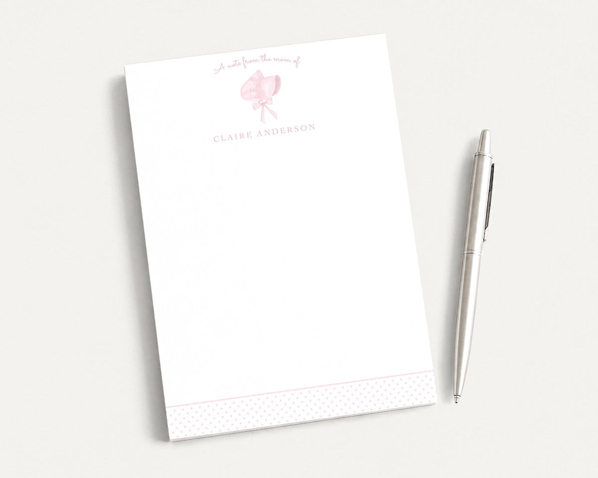 A white notepad with a pink design and the name "Claire Anderson" printed on it, along with a pen, are placed on a white surface. __etsy:8206459876