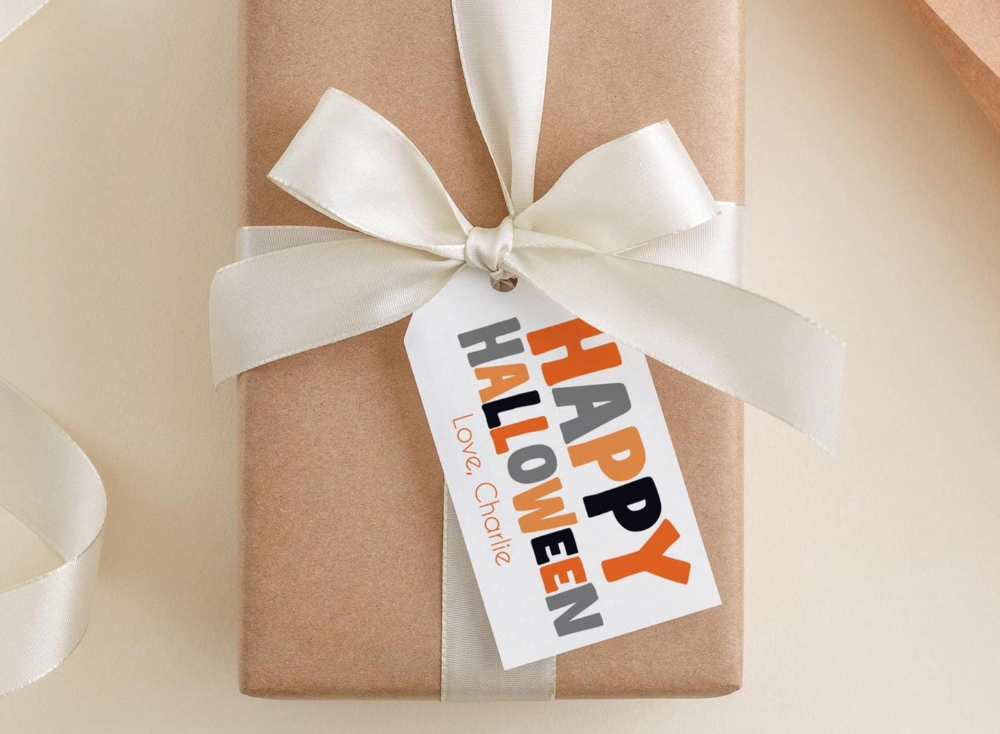 A brown gift box with a white ribbon and a tag that says "Happy Halloween Charlie".